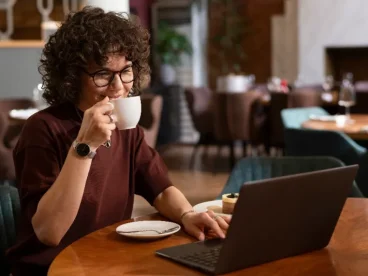 mulher tomando café enquanto trabalha de casa sentada no computador - produtos mais vendidos na shopee